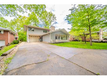 Charming two-story home features a long driveway, inviting curb appeal, and lush green landscaping at 806 Maplewood Ave, Anderson, IN 46012