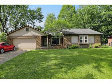 Charming single-story brick home with a well-manicured lawn and attached two-car garage at 8218 San Carlos Ct, Indianapolis, IN 46256