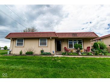 Charming single-story home with a red tile roof and a well-manicured green lawn at 8362 Punto Alto Dr, Indianapolis, IN 46227