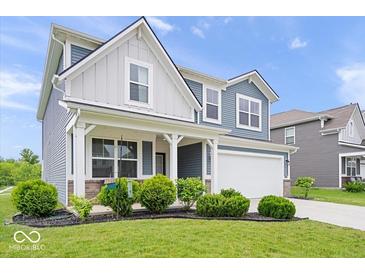 Charming two-story home with blue siding, white trim, covered porch, landscaped yard, and attached two-car garage at 10419 Pronghorn Ln, Indianapolis, IN 46239