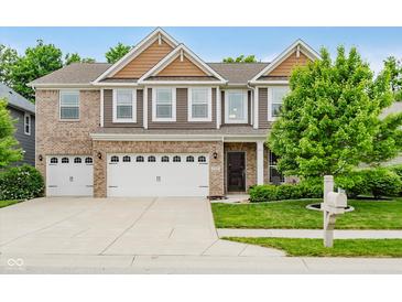 Charming two-story brick and siding home with a well-manicured lawn and attached two-car garage at 1274 Timber Bluff Rd, Westfield, IN 46074