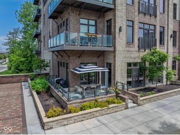 Stunning condominium with brick facade, glass balconies, and a private patio area at 15 W Executive Dr # 101, Carmel, IN 46032