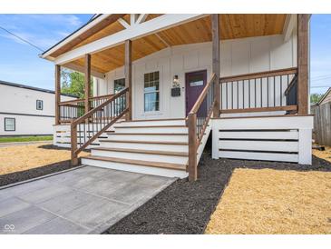 Close-up of a charming covered front porch with wood railings and a modern entrance at 1825 E Maryland St, Indianapolis, IN 46201