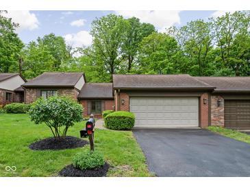 Charming brick home featuring a two-car garage, well-maintained lawn, and inviting curb appeal at 5353 Chipwood Ln, Indianapolis, IN 46226