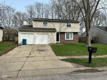Charming two-story home featuring a well-maintained lawn and an attached two-car garage at 5735 Liberty Creek E Dr, Indianapolis, IN 46254