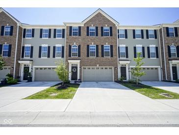 Charming townhome featuring a well-maintained lawn, attached garage and inviting curb appeal at 6871 Adalene Ln, Carmel, IN 46033