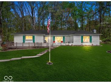 Charming single-story home featuring a well-maintained lawn, wood deck, and inviting curb appeal at 8581 N Goat Hollow Rd, Mooresville, IN 46158
