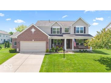 Charming two-story home with a brick facade, covered porch, and well-manicured lawn at 8635 Nolan Dr, Fishers, IN 46038