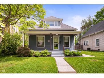 Charming blue two-story home with a cozy front porch and landscaped front yard at 117 S Spencer Ave, Indianapolis, IN 46219