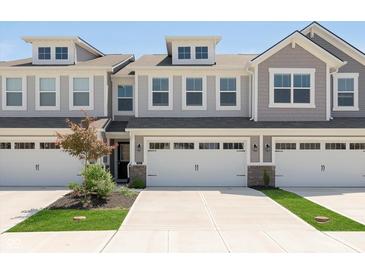 Attractive townhouse featuring a two-car garage, dormer windows, and green landscaping at 1237 Langham St, Avon, IN 46123