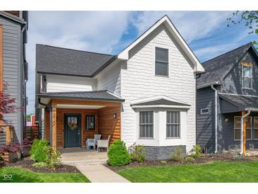 Charming two-story home with a welcoming front porch and beautifully landscaped front yard at 1310 Olive St, Indianapolis, IN 46203