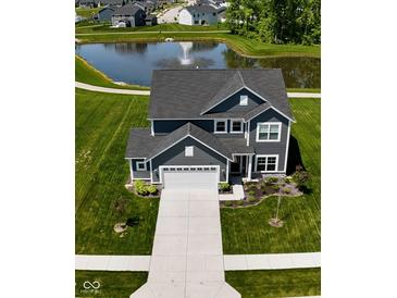 Beautiful home with gray siding, a large yard, and a pond with a fountain in the backyard at 3980 Railhead Ave, Westfield, IN 46074