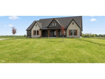 Charming stone and dark siding farmhouse with large front yard and beautiful landscaping at 4457 E County Road 850 N, Pittsboro, IN 46167