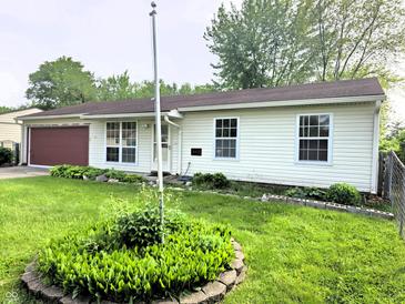 Charming single-story home featuring vinyl siding, a red garage door, and well-maintained front yard at 5416 Straw Hat Dr, Indianapolis, IN 46237
