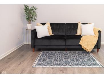 Living room featuring a black couch, accent pillows, and area rug at 8317 Pine Branch Ln, Indianapolis, IN 46234