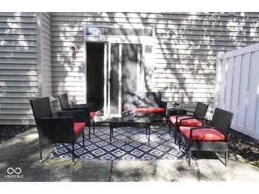 View of the rear patio with outdoor seating, a decorative rug, and a sliding glass door entrance at 8317 Pine Branch Ln, Indianapolis, IN 46234