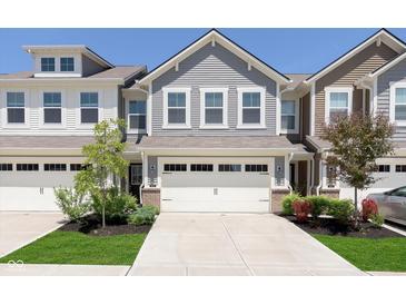Charming townhome with attached two-car garage and manicured front lawn at 9604 Beckett St, Avon, IN 46123