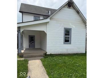 Charming home featuring white siding, a welcoming front porch, and a well-maintained lawn at 1322 S Belmont Ave, Indianapolis, IN 46221