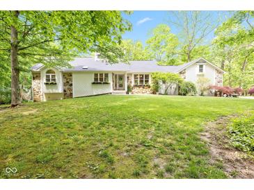 Charming ranch-style home with stone accents, flower boxes, and a large, well-manicured lawn at 13300 Fairwood Dr, McCordsville, IN 46055