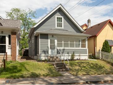 Charming home featuring gray siding, a well-kept lawn, and inviting front steps to the front door at 1661 S Talbott St, Indianapolis, IN 46225