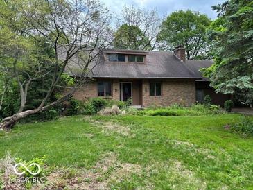 Charming brick home with a landscaped front yard, mature trees, and a cozy, inviting appearance at 310 S Shady Ln, Muncie, IN 47304