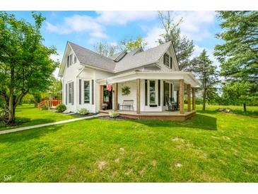 Charming two-story farmhouse with a covered porch and well-maintained lawn at 5335 W 550 S, Trafalgar, IN 46181