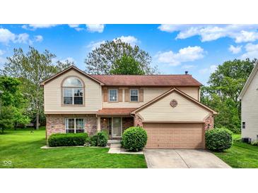 Charming two-story home with a well-manicured lawn and attached two car garage at 6609 Fountain Springs Blvd, Indianapolis, IN 46236