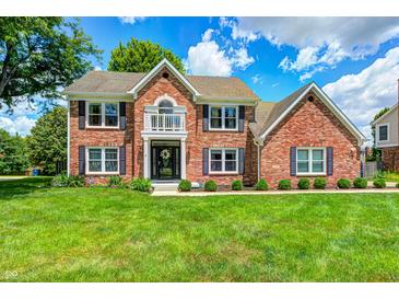 Charming two-story brick home with manicured lawn, black shutters, and classic architectural details at 9158 Oak Knoll Ln, Fishers, IN 46037
