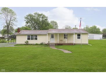 Charming single-story home featuring a well-maintained lawn and inviting front porch with an American flag at 125 S Alfonte St, Ingalls, IN 46048