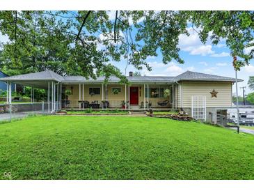 Charming ranch home with inviting front porch, lush lawn, and convenient carport at 313 E South St, Morristown, IN 46161