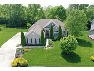 Stunning aerial view of brick home with pristine landscaping and mature trees providing shade and privacy at 3815 Harrison Crossing Ln, Greenwood, IN 46142