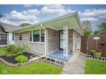 Charming single-story home featuring a well-maintained lawn and a welcoming front entrance with unique architectural details at 5225 E St Clair St, Indianapolis, IN 46219