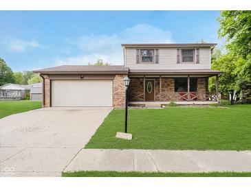 Charming two-story home featuring a brick facade, a two-car garage, and a well-manicured front lawn at 5236 Honey Comb Ln, Indianapolis, IN 46221