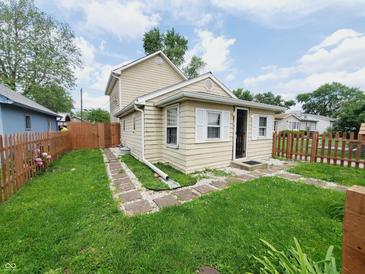 Charming tan two-story home with a small front yard and stone walkway to the front door at 704 E Perry St, Indianapolis, IN 46227