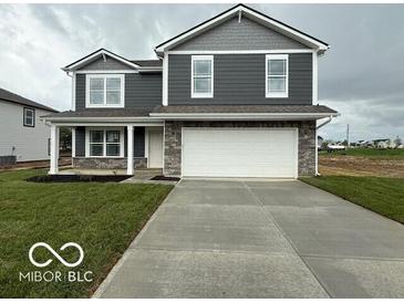 Two-story home featuring gray siding, white trim, and a two-car garage in a well manicured yard at 7605 Big Bend Blvd, Camby, IN 46113