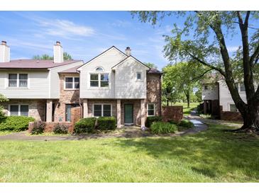 Charming townhouse with a well-maintained lawn and beautiful landscaping at 9572 Maple Way, Indianapolis, IN 46268