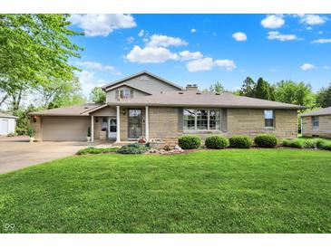 Charming two-story home featuring a stone facade and a lush green lawn at 10036 E Troy Ave, Indianapolis, IN 46239