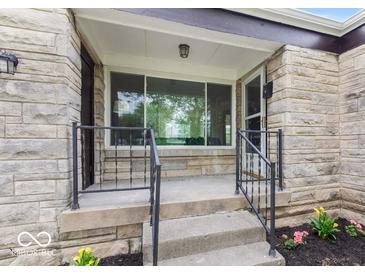 Inviting front porch with stone details and decorative railing welcomes you home at 1108 N Ritter Ave, Indianapolis, IN 46219