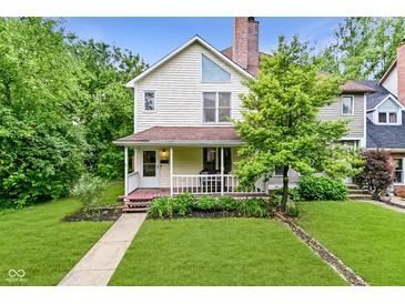 Charming two-story home featuring a cozy front porch, mature landscaping, and a well-maintained lawn at 1236 Central Ave, Indianapolis, IN 46202