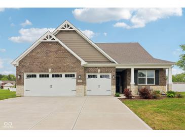 Charming brick home featuring a large three car garage and well-manicured lawn at 1270 Shaw Ln, Shelbyville, IN 46176