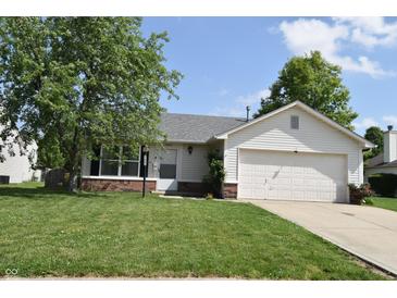 Charming single-story home featuring a well-maintained lawn and attached garage on a sunny day at 1652 Sweetwater Ln, Greenfield, IN 46140