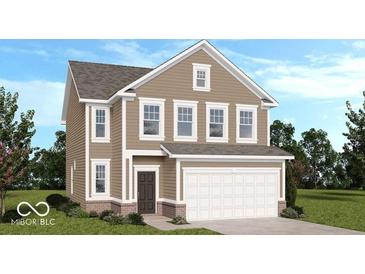 Charming two-story home with a brick foundation, inviting front door, two-car garage and neutral tan siding at 1980 Black Oak Dr, Shelbyville, IN 46176