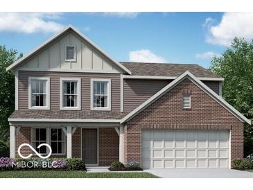 Charming two-story home featuring a brick and siding exterior with a two-car garage and well-maintained landscaping at 310 Atlas Dr, Lebanon, IN 46052