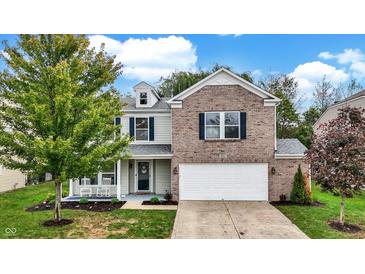 Beautiful two-story home with brick and siding, a well-manicured lawn, and inviting front porch at 3221 Holt St, Whiteland, IN 46184