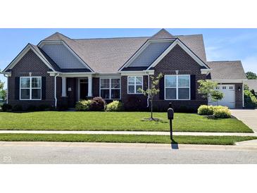 Beautiful brick home with a manicured lawn, complemented by lush landscaping and a welcoming entrance at 3691 Talmine Ln, Bargersville, IN 46106