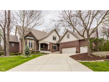 Beautiful brick home with a manicured lawn, mature trees, and a spacious driveway at 4037 Oakleaf Dr, Zionsville, IN 46077