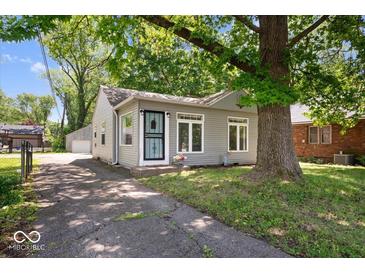 Cozy home featuring light gray siding, an inviting entryway, and a mature tree shading the property at 4809 Allisonville Rd, Indianapolis, IN 46205