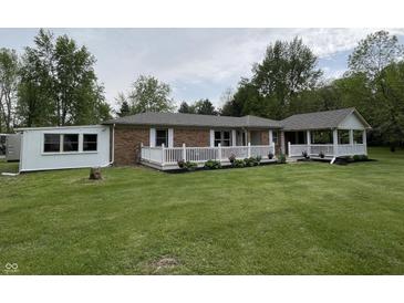 Charming brick home featuring a spacious front yard and white railed porch, perfect for relaxing outdoors at 5725 W 200 N, Lebanon, IN 46052