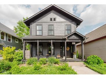 Charming two-story home featuring a covered front porch and beautifully landscaped yard at 584 S 10Th St, Noblesville, IN 46060