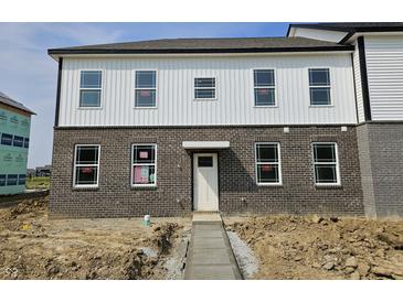 A view of the exterior of the house featuring a brick and white siding and a gray concrete walkway at 6150 Cascades Dr, Whitestown, IN 46075